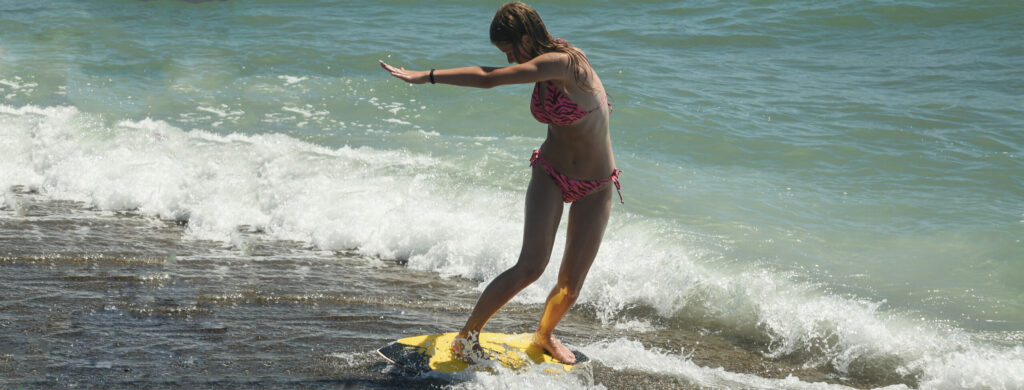 Uczestniczka obozu na ślizgająca się na skimboardzie podczas obozu z Erą Wyzwań