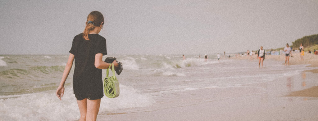 Uczestniczka obozu młodzieżowego nad morzem Bałtyckim spacerująca po plaży