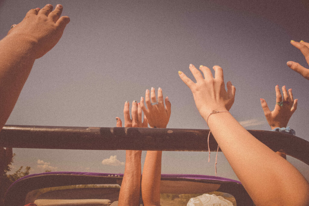 Wyciągnięte w górę ręce zadowolonych uczestników podczas przejażdżki Buggy Trip