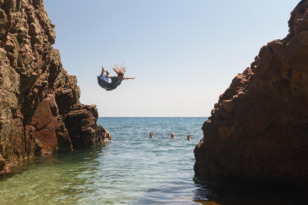 Efektowne zdjęcie uczestniczki obozu młodzieżowego Era Wyzwań, która skacze do wody w sukience