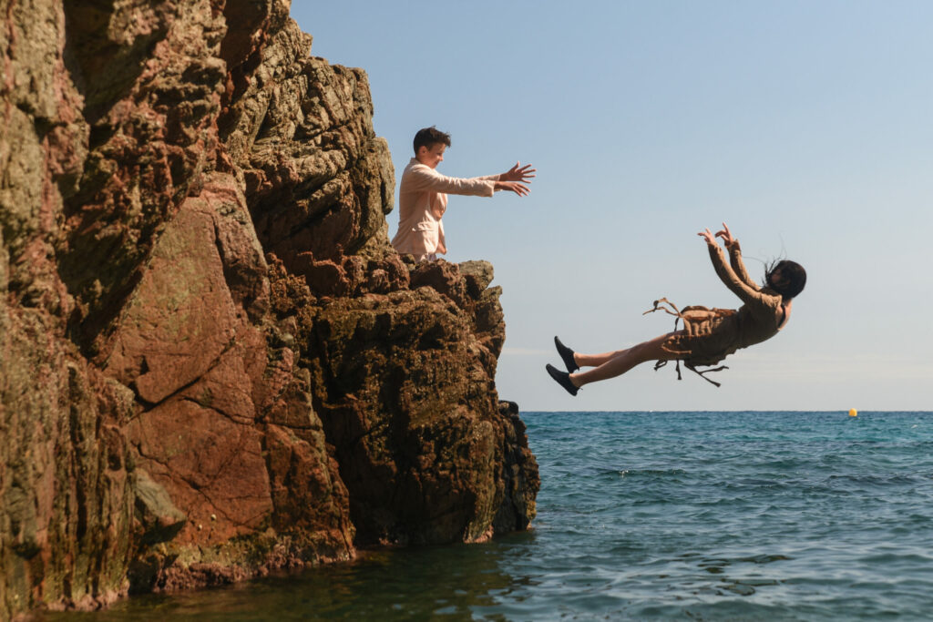 Zabawne zdjęcie wykonane podczas obozu młodzieżowego do Hiszpanii z Erą Wyzwań na którym chłopak w garniturze wrzuca do wody dziewczynę w sukience