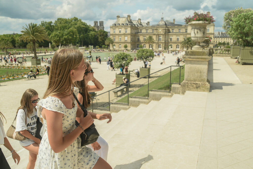 Uczestniczki obozu młodzieżowego podczas wycieczki w Paryżu na schodach w Ogrodach Luksemburskich