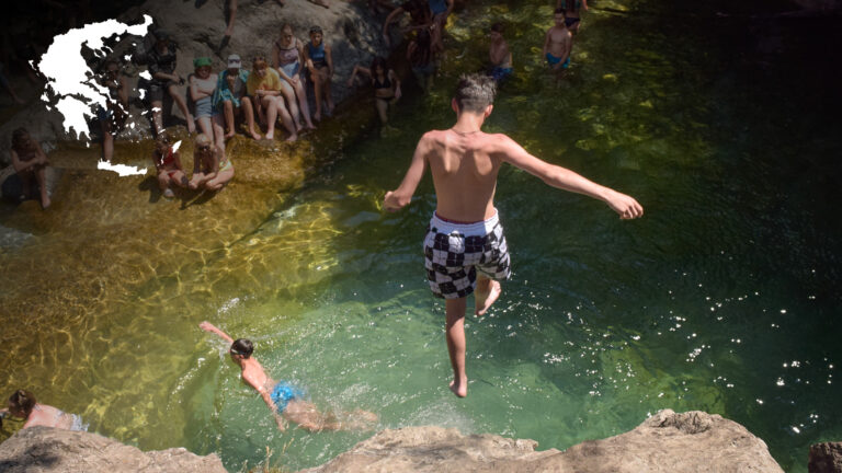 Zdjęcie uczestnika, który skacze do wody obok wodospadu w Grecji