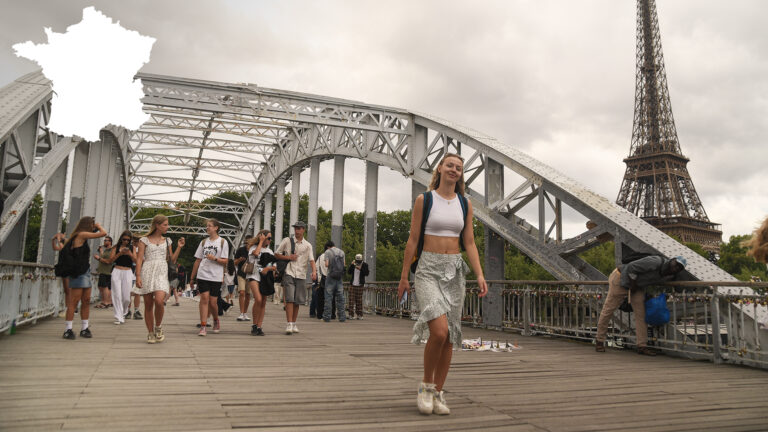Zdjęcie pieszej kładki w Paryżu po której idą uczestnicy