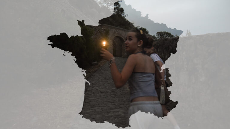 Uczestniczka obozu młodzieżowego z latarką idąca do Cytadeli w Entrevaux