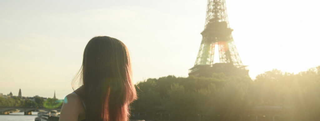Dziewczyna spoglądająca na Wieżę Eiffla o wschodzie słońca na obozie młodzieżowym do Hiszpanii i Francji