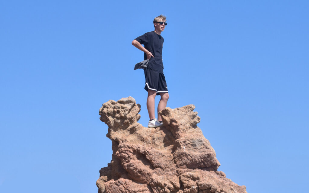 Uczestnik obozu do Hiszpanii stojący na skale i spoglądający w dal